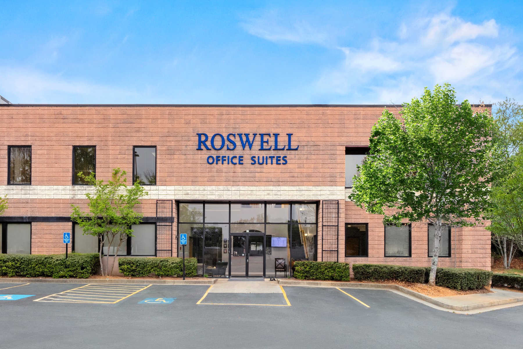 Front entrance of Roswell Office Suites with the building sign and glass doors
