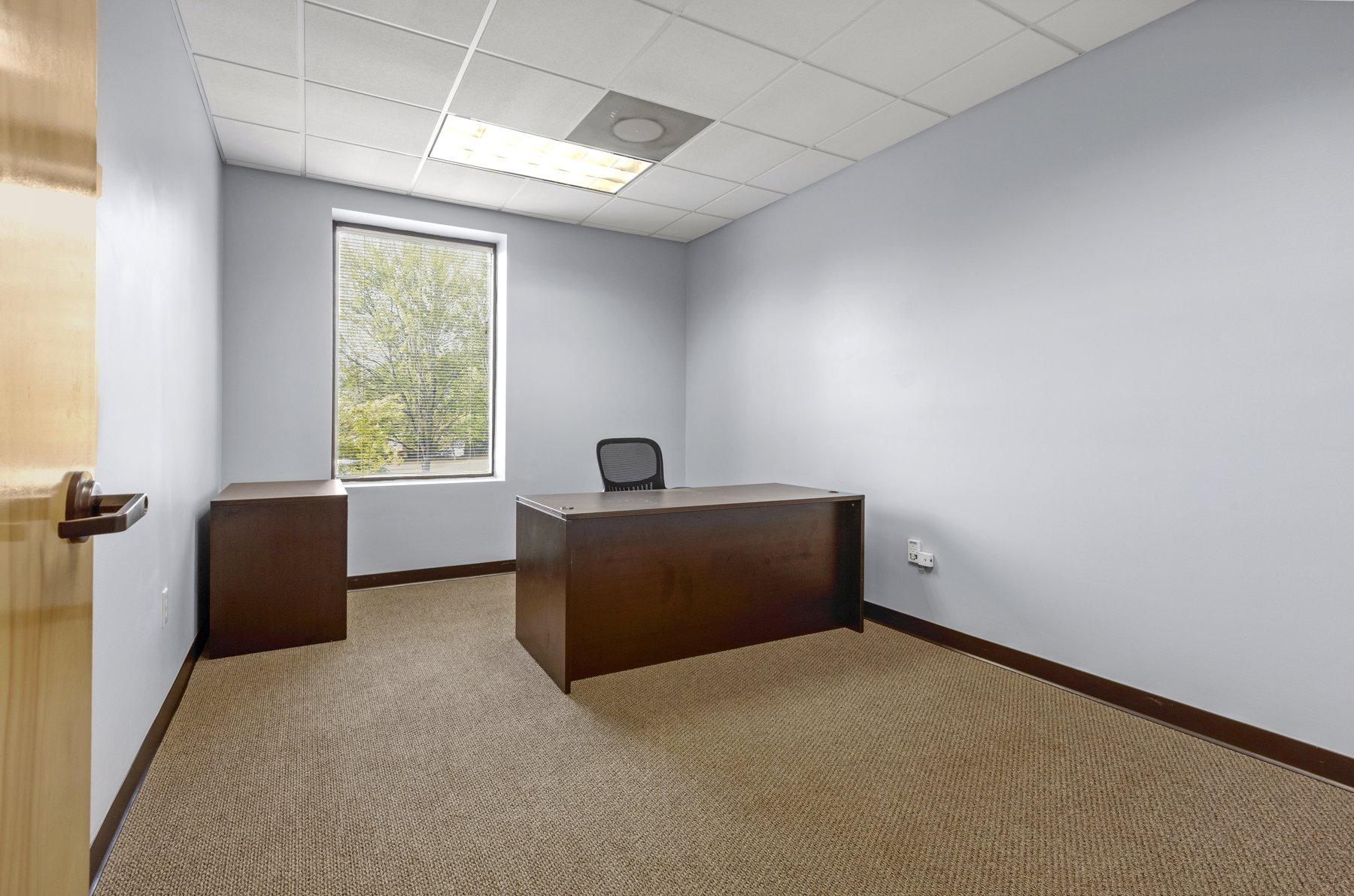 Move-in ready private office at Roswell Office Suites with desk and window light