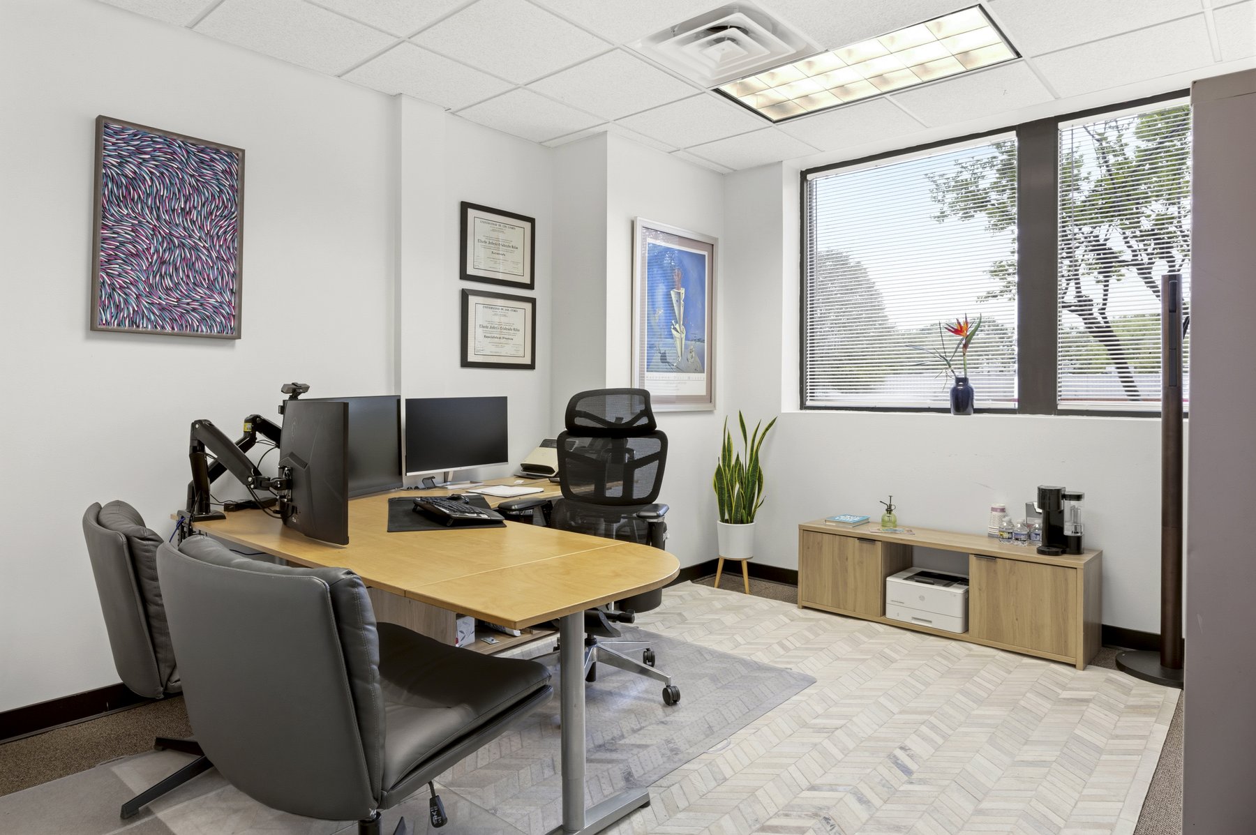 Furnished private office at Roswell Office Suites with desk, dual monitors, ergonomic chair, and natural light